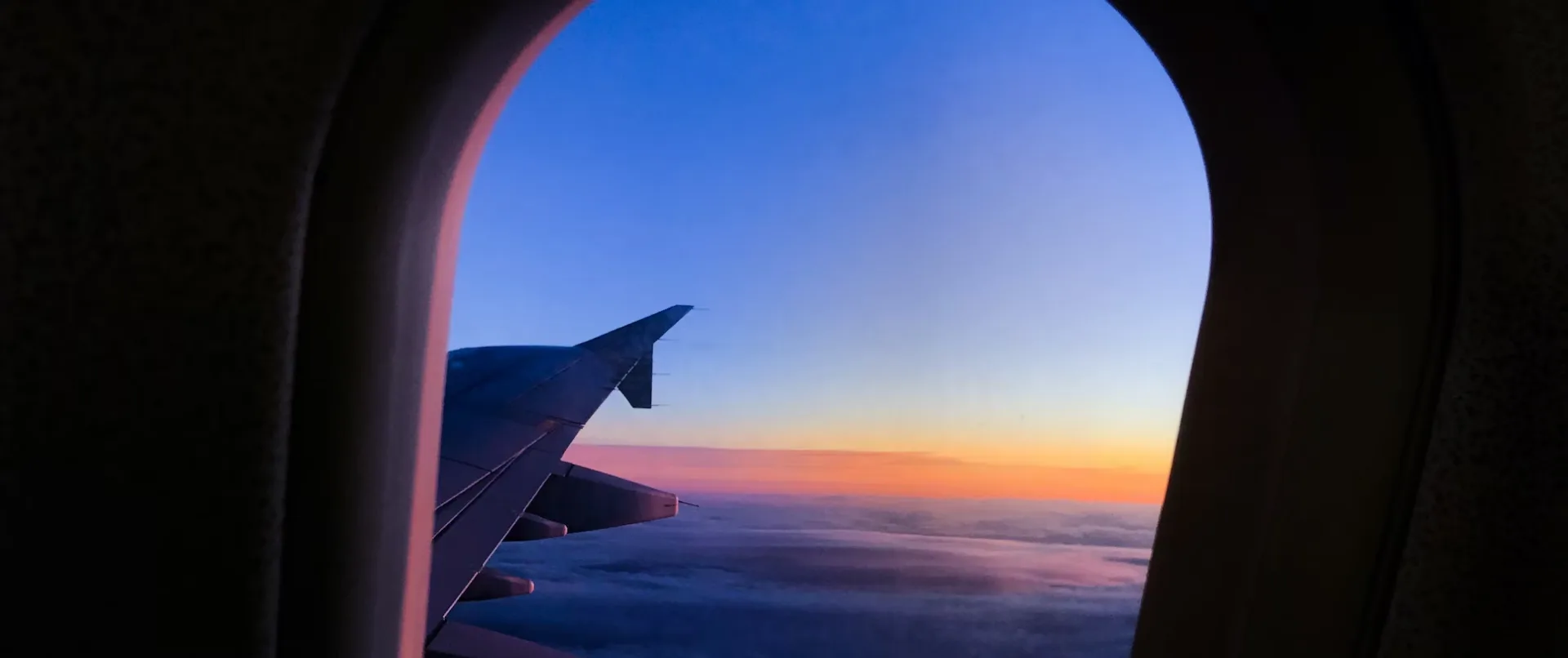 Vista desde la ventanilla de un avión al atardecer, camino hacia Canadá.